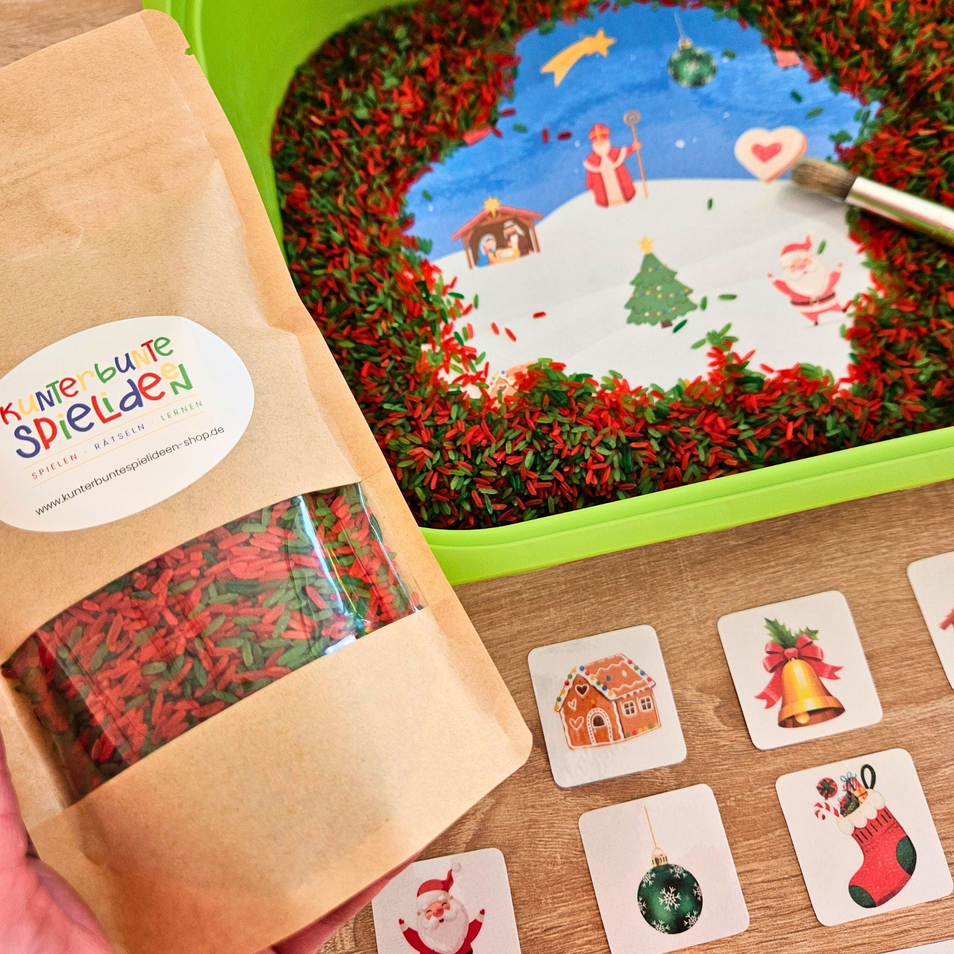 Beutel mit rot-grünem Regenbogenreis neben Weihnachtskarten – ideal fürs Aktionstablett Weihnachten in Kita & Zuhause.