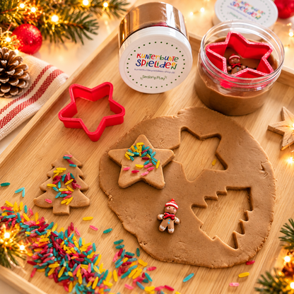 Weihnachtsbäckerei Knetset für Kinder mit brauner Knete in der Dose, rotem Stern-Ausstecher, bunten Reisstreuseln und Lebkuchenmännchen zum Plätzchenspielen.