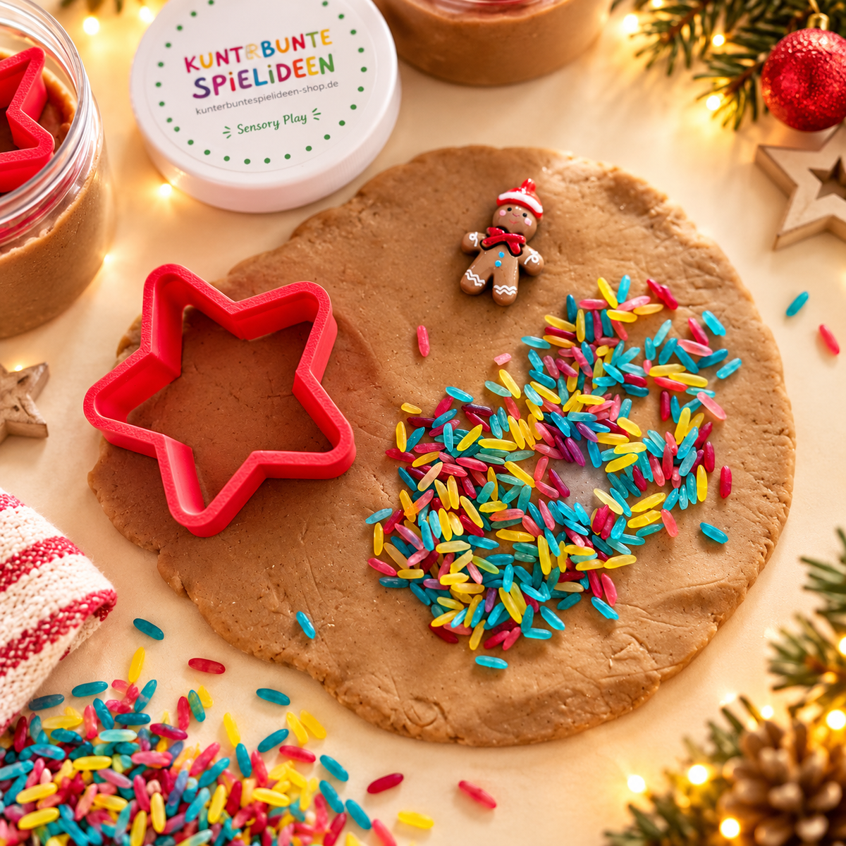Weihnachtsknete für Kinder zum Plätzchen ausstechen und Verzieren – ausgerollte braune Knete mit rotem Stern-Ausstecher, bunten Reisstreuseln und Lebkuchenfigur.