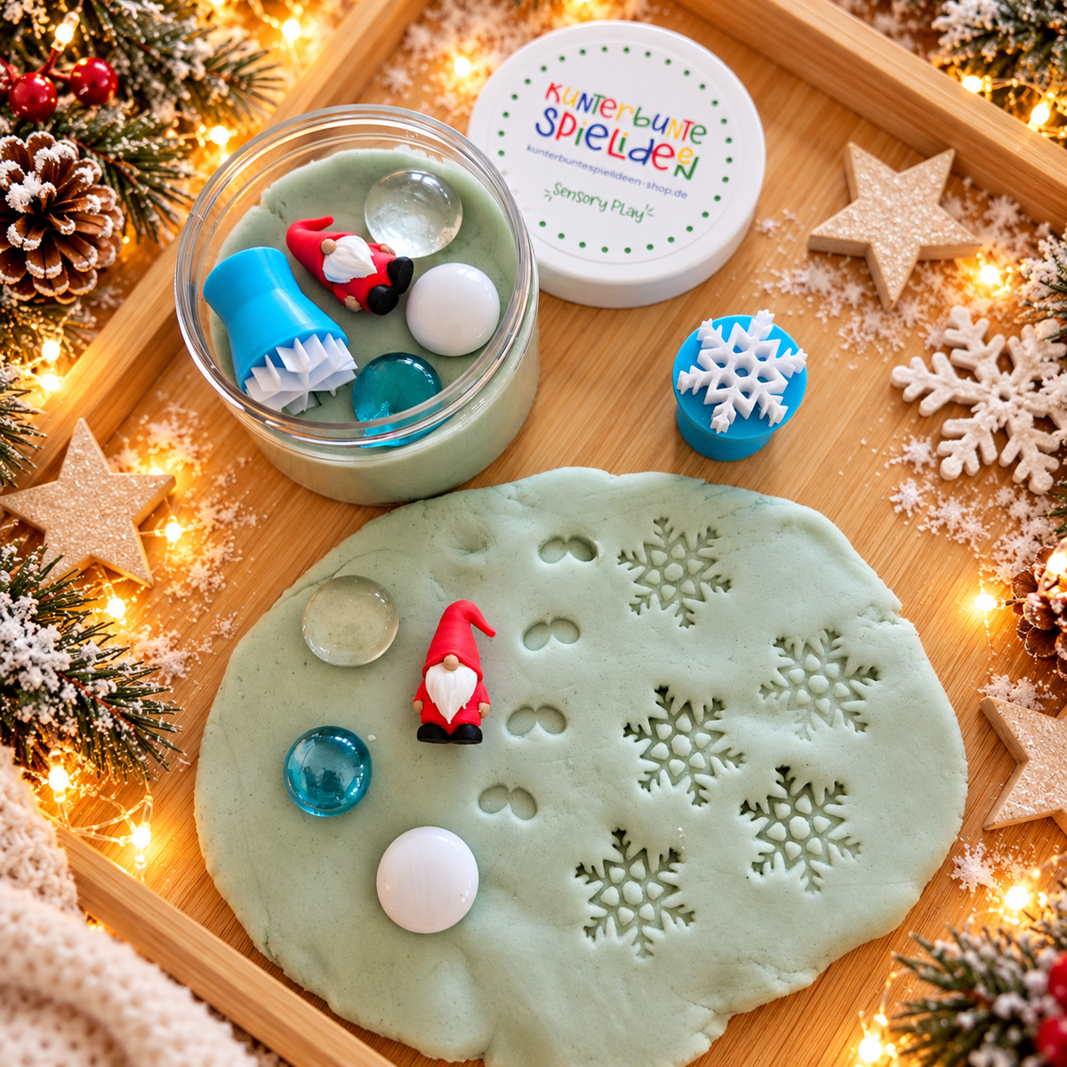 Wichtel-Knetset als Überraschung für die Wichteltür mit grüner Schneeknete, rotem Miniwichtel, Schneeflockenabdrücken und drei Muggelsteinen.