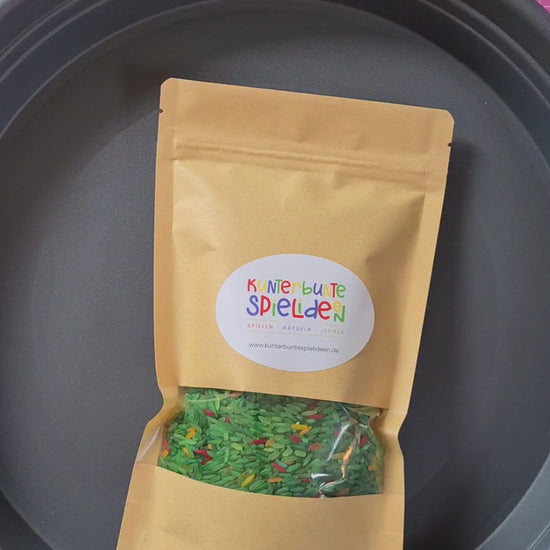 Sensory Play mit gefärbten Reis und Tierfigur Einhorn als kleines Geschenk für sensorisches Spiel