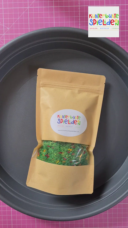 Sensory Play mit gefärbten Reis und Tierfigur Einhorn als kleines Geschenk für sensorisches Spiel