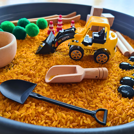 Montessori Sinnesspiel Baustelle für Kinder mit sensorischem Reis, Baustellenfahrzeug, Schüttwerkzeugen und losen Materialien für Schüttspiele, Sensory Play und sensorisches Spiel. Fördert Feinmotorik, Konzentration und Sinnesförderung bei kleinen Baustellenfans.